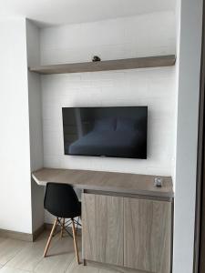 马尼萨莱斯Apartamento de lujo Manizales的一张桌子,电视机和椅子放在房间里