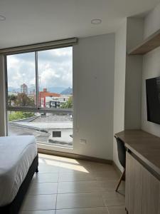 马尼萨莱斯Apartamento de lujo Manizales的一间卧室设有一张床和一个大窗户