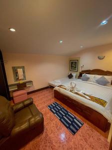 洛坤府JB Grand Resort的一间大卧室,配有一张大床和一张沙发