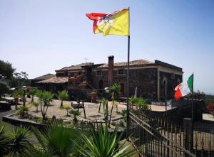 拉加尔纳Villa Casina dell'Etna的两面旗帜在建筑物前面飞