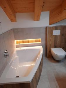 利维纳隆戈德尔科Appartamento l’ Aier - Arabba - Dolomiti的浴室配有白色浴缸和卫生间。