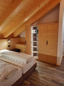 利维纳隆戈德尔科Appartamento l’ Aier - Arabba - Dolomiti的一间卧室设有一张床和木制天花板