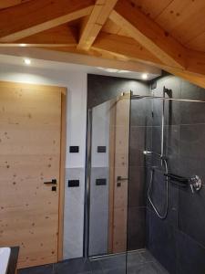 利维纳隆戈德尔科Appartamento l’ Aier - Arabba - Dolomiti的带淋浴的浴室和木门。