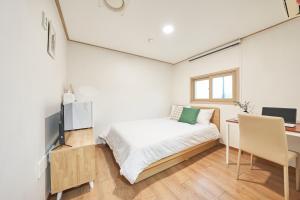 首尔K'STAY Sinchon的一间小卧室,配有一张床和一张书桌