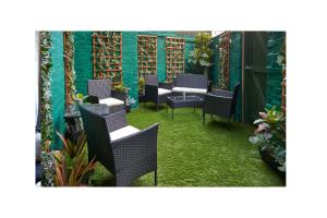 利物浦Home @ 2 Tancred Road的一个带桌椅的庭院和绿色的墙壁