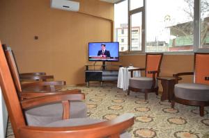 阿德亚曼瓦迪伊莱蒙酒店 的一间配有平面电视和椅子的等候室