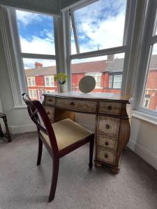 利物浦Liverpool Victorian Townhouse - 3 Bedrooms的窗户前带椅子的桌子