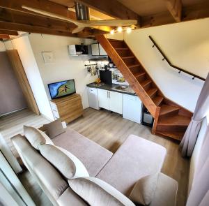 勒唐蓬Tiny House Chaleureuse au Style Contemporain Minimaliste的带沙发和楼梯的客厅