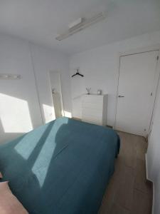 厄尔-汝姆披多Apartamento moderno frente a la playa San Miguel的一间白色客房内的蓝色床卧室