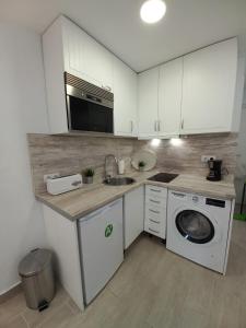 厄尔-汝姆披多Apartamento moderno frente a la playa San Miguel的厨房配有水槽和洗衣机