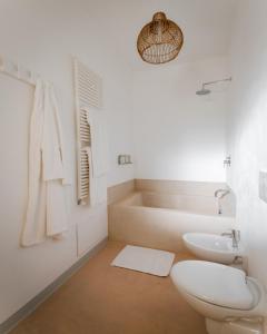 奥里亚Palombara Masseria & SPA - Adults Only的浴室配有卫生间、盥洗盆和浴缸。