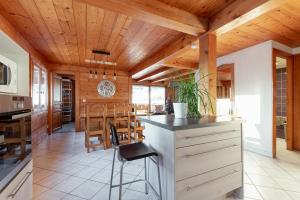 Les Villards-sur-ThônesLes Picaillons - Le gîte的一间带木制天花板的厨房和一间餐厅