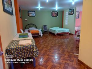 万查科Casa Familiar Eventos y Recepciones Huanchaco Huanchaquito的客房铺有木地板,配有两张床。