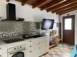 Tajace de AbajoLa Cuadra de Pascuala的一个带水槽的厨房和墙上的电视