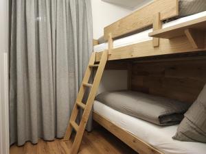 圣坎迪朵Appartements Stoll的配有梯子的小客房内的双层床