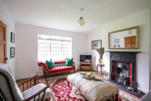 威勒尔Duke of York Cottage, Port Sunlight的客厅设有红色的沙发和壁炉