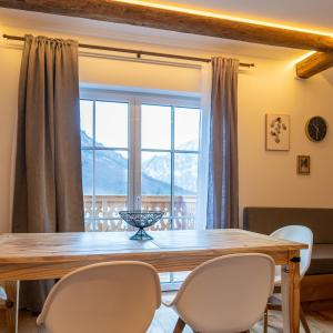 巴特奥塞Haus Stangl的一间带桌椅和大窗户的用餐室