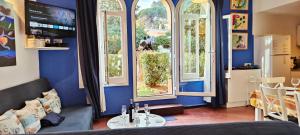 帕拉莫斯Casa con jardín a 30 metros de la playa. VC.的一间拥有蓝色墙壁、窗户和桌子的客房