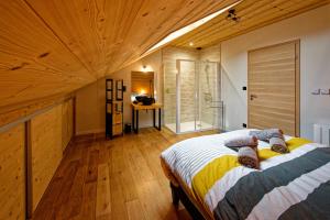 CutturaLes balcons de Cuttura 2 chez Ô JurassiK的一间卧室设有一张床和木制天花板