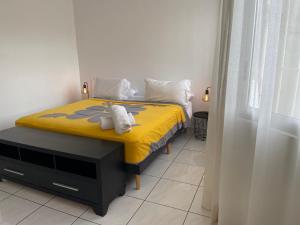 帕皮提Manaeva L3的一间卧室配有黄色的床和毛巾
