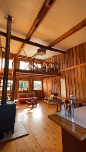 PueloLa Ruka Negra的大型客厅设有木墙和木地板