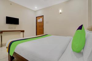 海得拉巴Treebo Trend Virat Residency - US Consulate的卧室配有白色的床和电视。