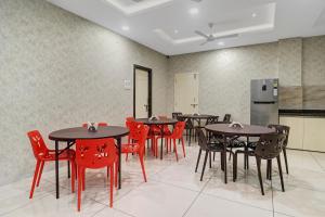 海得拉巴Treebo Trend Virat Residency - US Consulate的用餐室配有桌子和红色椅子