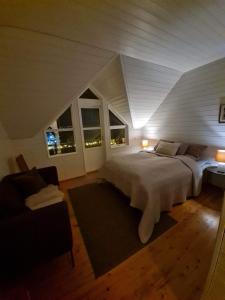 特罗姆瑟Cozy little house in Tromsø city的卧室配有一张白色的大床和一张沙发。