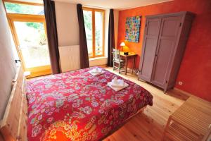 艾吉耶雅克艾文莉酒店的一间卧室配有红色的床和2条毛巾