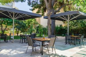 雅典阿科波罗酒店的一个带桌椅的遮阳伞下庭院
