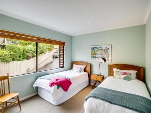 北哈夫洛克Busby Hill Villa - Havelock North Holiday Home的带窗户的客房内的两张床