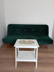 科瓦科瓦Spa Apartmán Kováčová的绿色沙发、白色咖啡桌和绿色长凳