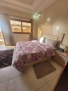达喀尔Résidence Hadja 01的一间卧室设有一张大床和一个窗户。