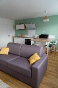 LempdesCasa Ragazzi - Refait à neuf - Calme - Parking的客厅配有紫色沙发,设有厨房