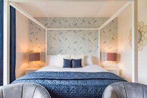 梅德斯通Luxurious & Modern Large 5 Bed House, HotTub, Views!的一间卧室配有一张带蓝色被子的床和两把椅子