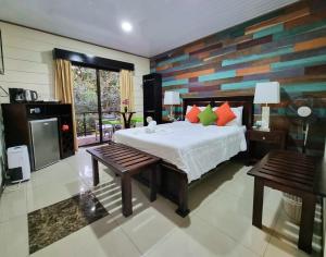 蒙泰韦尔德哥斯达黎加Calathea Lodge Monteverde的一间卧室配有一张床和两张长椅
