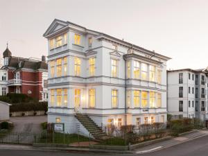 黑灵斯多夫OSTKÜSTE - Villa Groth Design Apartments的白色的建筑,有黄色的灯光