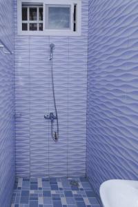 Maison Bethel Kpogan Afidenigba的蓝色瓷砖浴室设有淋浴和窗户