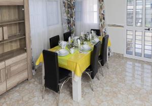 Maison Bethel Kpogan Afidenigba的用餐室配有黄色的桌子和椅子
