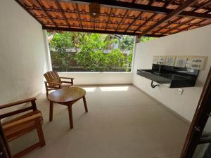 GarapuáCanoa Azul的客房设有椅子、书桌和窗户。