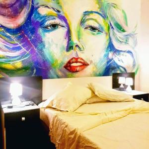 蒙得维的亚Montevideo Port Hostel的一张墙上的女人在床边的画