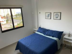 Santa TeresitaBeautiful Apartment in Vista Mar Golf, Beach & Marina的一间卧室设有蓝色的床和窗户。