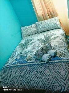 圣费尔南多DesMaries Pleasantville的一张带蓝色和白色床单及枕头的床