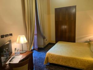 那不勒斯乐德尔精品酒店的酒店客房配有一张床、一张书桌和一盏灯。