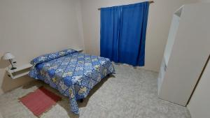 阿尔韦亚尔将军镇Casa con pileta privada的一间卧室配有床和蓝色窗帘