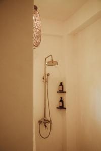 卢纳将军城Vedya Boutique Hostel的带淋浴的浴室,墙上有灯