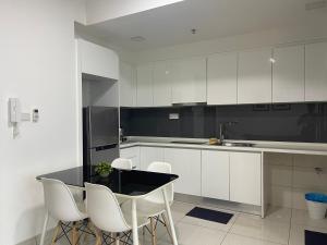努沙再也Almas Suites Double Bed @Legoland的厨房配有白色橱柜和桌椅