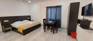 提喀迪Thekkady Travel Rooms的一间卧室配有一张床、一张书桌和一台电视