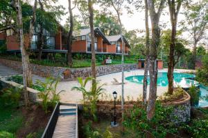 瓦亚纳德Crystal Kuruva Nature Resort & Spa的度假村前带游泳池的房子