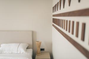 拉差汶里Navela Hotel & Convention的一间卧室,配有一张床和一张桌子上的花瓶